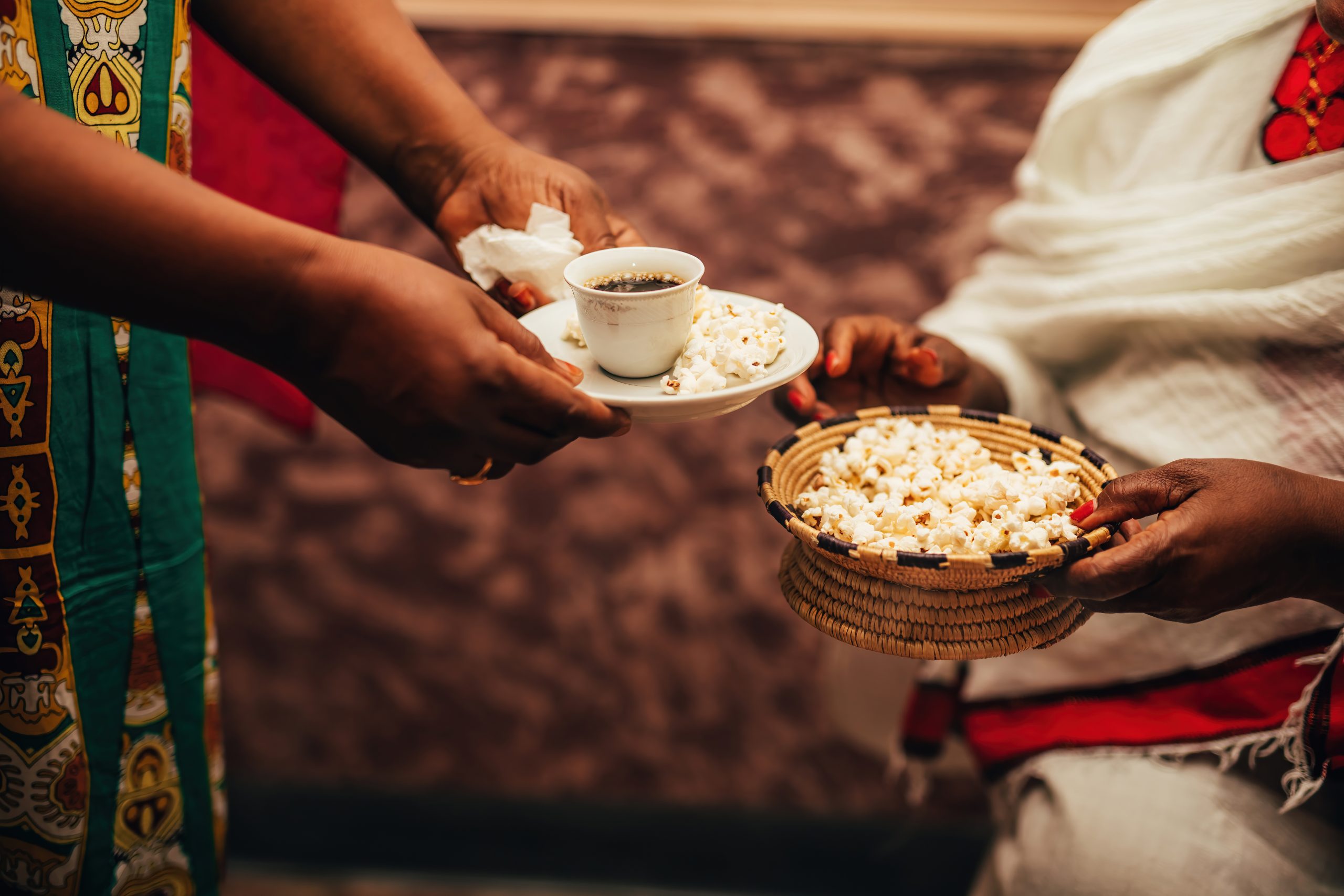 ethiopian women in coffee ceremony exchanging popcorn and coffee